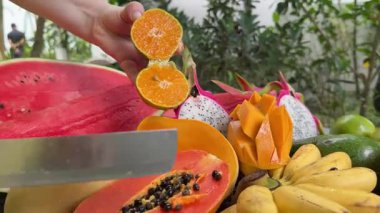 Lezzetli tropikal meyveler, sağlıklı yiyecek, mango, muz meyve, karpuz portakalları ve arka planda diğer sulu Asya palmiye yaprakları. Yüksek kalite 4k görüntü