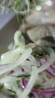 Tabakta ringa balığı servis et. Mikroyeşillik fileto ile süsle. Tabakta parçalara ayır. İsteyen istemciye sunmadan önce aperatif sunumunun son detaylarını tamamlayan dikkatli usta