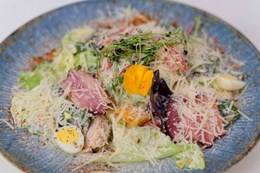 Tavuk Sezar salatası kasesi masada. Parmesan yumurtalı Sezar salatası.