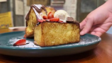 Kahvaltınız koyu bir tabakta duruyor. Lüks bir restoranda çilek, çikolatalı dondurma ve pudra şekerle servis ediliyor. Yüksek kalite 4k görüntü