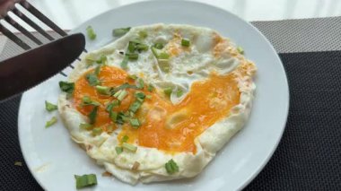 İki sahanda yumurta, yeşil soğanlı yeşil soğanlı kırmızı biberli bir tabakta otel yumurtasının yumurta sarısı, yumurta sarısı ve sağlıklı omlet. Yüksek kalite 4k görüntü