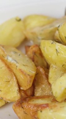 Kırsal tarzda kızarmış patates, baharatlar, biberiye ve ahşap bir masada taze domatesler, fırından fırına yakın patates kızartması.