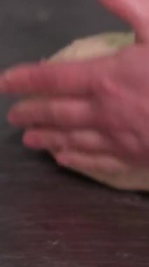 Un kaplı yüzeyde hamuru şekillendiren eller. Kalıpları ekmek hamuruyla doldur.