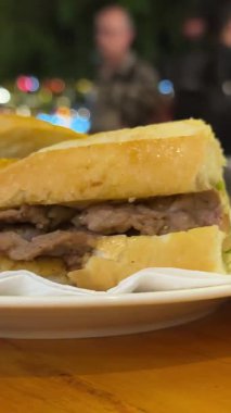 Banh mi bun, Vietnam köftesi. Beyaz bir plaka üzerinde yemek dağıtan elin 4K görüntüsüne bak.