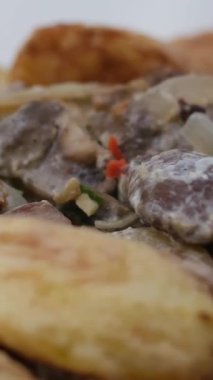 Kızarmış soğanlı krema ile sıcak patates pişirme süreci kızartma tavasında bir tabak üzerine çok lezzetli Slav Ukrayna yemeği serpiştirip sarımsaklı iştah açıcı sıcak kızartma tavası serpiyor. 4k görüntü