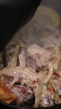 Kızarmış soğanlı krema ile sıcak patates pişirme süreci kızartma tavasında bir tabak üzerine çok lezzetli Slav Ukrayna yemeği serpiştirip sarımsaklı iştah açıcı sıcak kızartma tavası serpiyor. 4k görüntü