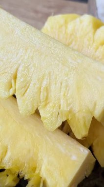 Masanın üzerindeki bir tabağın üzerinde taze, sulu, olgun ananas parçaları. Bir kadın eli onları alır ve kameranın üzerine koyar. Yavaş çekimde meyve veren Asya.,