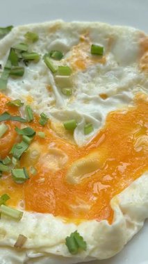 İki sahanda yumurta, yeşil soğanlı yeşil soğanlı kırmızı biberli bir tabakta otel yumurtasının yumurta sarısı, yumurta sarısı ve sağlıklı omlet. Yüksek kalite 4k görüntü