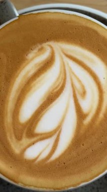 Sabah kapuçino sanat kahvesi ahşap masada. 