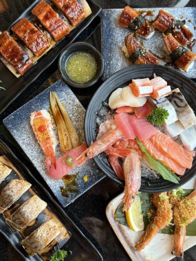 Suşi Sashimi ve suşi ruloları taş levhada servis edilir. dikey karides yılan balığı fotoğrafları