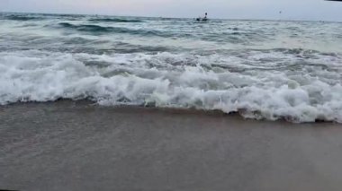 Büyüleyici okyanus dalgaları kumlu kıyı şeridi üst hava manzarası. Okyanusun görkemli dalgaları kumsalın sakin dalgaları okyanus kenarındaki güzel okyanus manzarasının sükunetini okşar. Yüksek