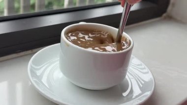 Erkek, Aromatik El Karıştırıcı Kupa Sıcak Çikolata 'da Şekeri Karıştırıyor. Taze Sabah Kahvesi. Yakın çekim. Ağır çekim. Beyaz Kupada Sütlü Sıcak Çikolata. Bir kafede kahve karıştırmak. Yüksek kalite 4k görüntü