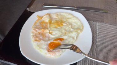 Yeşil tabakta kızarmış yumurta ve ekmek yemek. Yakın plan. Bakış açısı. Renkli arka plan. Tostlu geleneksel kahvaltı. Güneşli bir gün. Yüksek kalite 4k görüntü