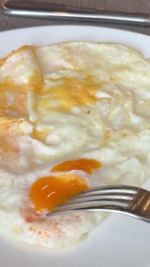 Yeşil tabakta kızarmış yumurta ve ekmek yemek. Yakın plan. Bakış açısı. Renkli arka plan. Tostlu geleneksel kahvaltı. Güneşli bir gün. Yüksek kalite 4k görüntü