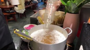 Şehirdeki ünlü Mot çayı insanlar sırada bekliyor. Büyük bir nilüfer çiçeği kabı dökülüyor. Turistler çay içmeye gidiyor.