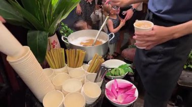 Şehirdeki ünlü Mot çayı insanlar sırada bekliyor. Büyük bir nilüfer çiçeği kabı dökülüyor. Turistler çay içmeye gidiyor.