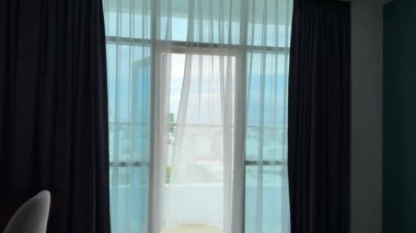 Saf beyaz perde Şeffaf beyaz perde tülleri rüzgardan açık bir pencereden hareket eder. Yüksek kalite 4k görüntü