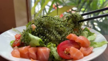 Lezzetli bir somon salatasının siyah kase karides yumurtasındaki videosu. Bu pek çok insanın sevdiği bir yemek, çünkü baharatı sağlıklı malzemelerden geliyor. Yüksek kalite 4k görüntü