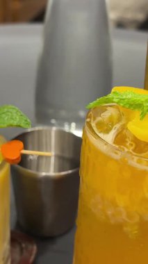 Mango tutkulu meyve portakallı Asya tropik içecekleri. Nane ve meyve parçalarıyla süslenmiş güzel bardaklar. Restoran kafe sokak yemeklerinde Vietnam. Yüksek kalite 4k görüntü