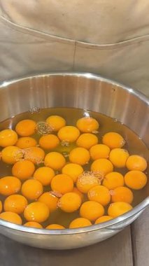 Bir sürü yumurta sarısı, yumurta beyazı, yemek hazırlayan bir sürü kadın. Kadın mutfakta cam kaseye yumurta kırıyor. Elleri yakın çekim. Yüksek kalite 4k görüntü