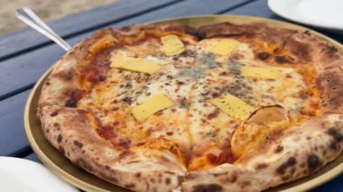 Pizza dört peynir, lezzetli geleneksel İtalyan pizzası. Elinle bir dilim pizza al, kapat. Peynir bir dilim pizzadan esniyor. Dört peynirli pizza. Yan görüş. Lezzetli bir yemek. Yüksek kalite 4k 