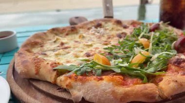 Yarısı peynirli, yarısı roka, yarısı sebzeli ev yapımı vejetaryen pizza, pizza kabuğuna roka, ağır çekim. Aile yaşam tarzı konsepti. Yüksek kalite 4k görüntü