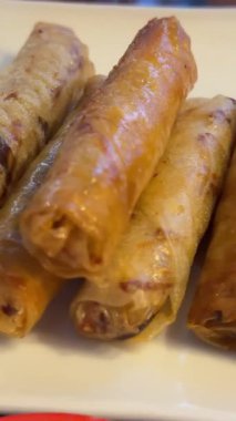 Tabakta börek ve siyah arka planda kırmızı biber sosu var. Yiyecek, içecek ve renk kavramı. Yüksek kalite 4k görüntü