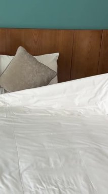 Pijamalı bir kadın akşamları yatar ve beyaz bir battaniyeyle üstünü örtür. Yatak odası, yatak odası ve masa lambası. Yüksek kalite 4k görüntü