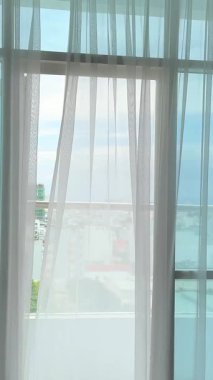 Saf beyaz perde Şeffaf beyaz perde tülleri rüzgardan açık bir pencereden hareket eder. Yüksek kalite 4k görüntü
