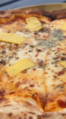 Pizza dört peynir, lezzetli geleneksel İtalyan pizzası. Elinle bir dilim pizza al, kapat. Peynir bir dilim pizzadan esniyor. Dört peynirli pizza. Yan görüş. Lezzetli bir yemek. Yüksek kalite 4k 