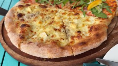 Sahilde yarım peynirli yarım peynirli sulu ve sulu bir pizza ve peynirli mozzarella peyniri. Yüksek kalite 4k görüntü