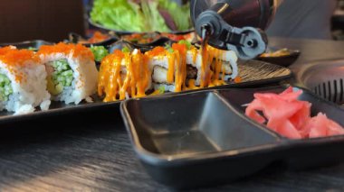 Suşi için soya sosunu lezzetli Asya yemeklerine dök California usulü zencefilli sosu restoran balık büfesine koy. Yüksek kalite 4k görüntü