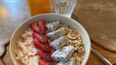 Taze sağlıklı meyve sularıyla taze kaseler ve güzel ahşap masa üzerinde meyve suları. Summer Meal of Raw Banana ve Acai Mash 'i yakından izle. Sevgililer Günü. Yüksek kalite 4k görüntü