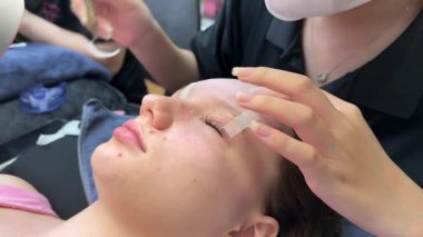 Modern güzellik salonunda ultraviyole lamba kullanarak kirpik uzatma prosedürünü kapat. Kusursuz uygulama teknikli yenilikçi kırbaç geliştirme teknolojisi. Yüksek kalite 4K görüntü. Yüksek