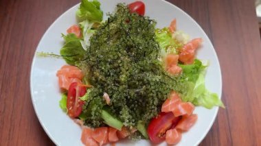 Somon balığı salatası aşçı soslu dürüm. Sebze, yosun ve balık. Ağır çekim. Yüksek kalite 4k görüntü