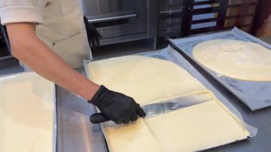 Pastanelerde tatlı yapma süreci hamur işi eldivenlerle çalışma kalıplardan daireler kesme pasta pişirme aşçısı tatlıları pişirme.