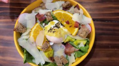 Salata, tuzlu somon, avokado, haşlanmış yumurta ve yeşil tabakta sebze. Yumuşak odaklanma. Yavaş çekim el kamerası videosu. Sağlıklı beslenme teması. Yüksek kalite 4k görüntü