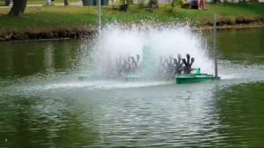 Tayland Bangkok görüntüsü göl veya gölde bir su püskürtücü gösteriyor. Havacının suyu döndüren birkaç dönen küreği var. Bu da önemli miktarda sıçrama ve yüzey çalkantısı yaratıyor.. 