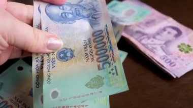 Vietnam para birimi banknotlarına yakından bak. Beş yüz bin dong 'luk banknot ve yavaş dönüş. Banknotlar düzgün ve düzgün bir şekilde düzenlenmiş. Vietnam Dong ve Tayland Bahti.