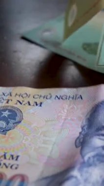 Vietnam para birimi banknotlarına yakından bak. Beş yüz bin dong 'luk banknot ve yavaş dönüş. Banknotlar düzgün ve düzgün bir şekilde düzenlenmiş. Vietnam Dong ve Tayland Bahti.