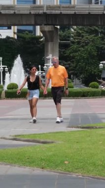 Şehir merkezindeki çeşmede insanlar yaz aylarında Tayland Bangkok 'ta kadın turistleri gezdiriyorlar. 06.10.2025