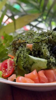 Sos ile doldurulmuş aşçı. Sebze, yosun ve balık. Ağır çekim. Yüksek kalite 4k görüntü