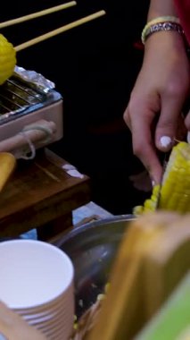 Sanur Beach, Bali, Endonezya sahilinde bir sokak satıcısı tereyağlı ve acı soslu mısır ızgara yapar. - Evet. Yüksek kalite 4k görüntü