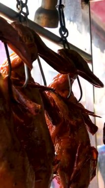 Bir mağazanın dışında büyük bir mağazada asılı duran kızarmış ördekler görülüyor. Yüksek kalite 4k görüntü