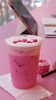 Buzlu, buzlu, buzlu ve naneli bir içecekle dolu cam bir bardağın videosu. Birkaç cam pencerenin önünde bir caddeyi gösteriyor. Yüksek kalite 4k görüntü