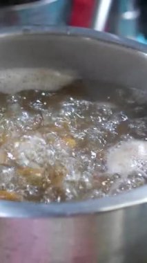 İtalyan makarnası çok yavaş bir şekilde kaynayan suyla tencereye dökülüyor ve mutfak aşçısının geleneksel yemek tarifleriyle pişiriliyor. Yüksek kalite 4k görüntü