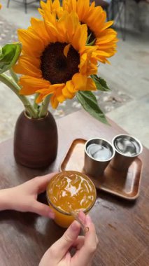 Kadın sarı meyve suyu detoks kokteyli içiyor. Yakından bakınca portakal suyunu bir bardakta tadıyor ve sabahları içkinin tadını çıkarıyor. Fitness ve sağlıklı yaşam tarzı konsepti. Yüksek kalite 4k görüntü