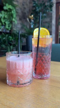 sitting on a table in a bar coffee shop pink drinks non-alcoholic cocktails drinks grapefruit juice. High quality 4k footage
