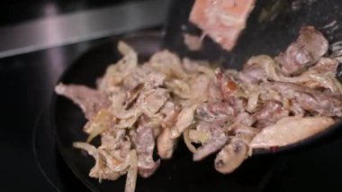 Yakın çekim, soğanlı leziz et ve açık ateş. Büyük bir tencerede ateş üstünde pilav pişirmek. Kızarmış et, tavada soğan. Üst Manzara. Yüksek kalite 4k görüntü