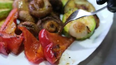 Izgara sebzeler çatal, mantarlar ve biberler ızgarada pişmiş sebzeleri tabağa koymak için çatal ve maşa kullanmak, bitkiler için sağlıklı vejetaryen yaşam tarzını ön plana çıkarmak.